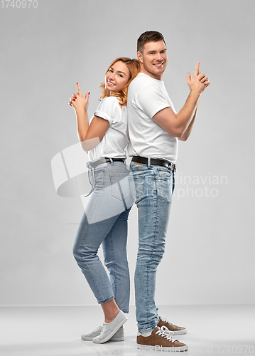 Image of couple in white t-shirts shirts making gun gesture