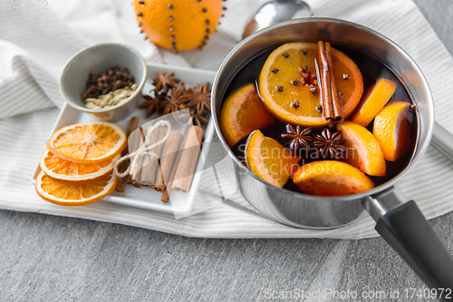 Image of pot with hot mulled wine, orange slices and spices