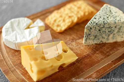 Image of different cheeses and crackers on wooden board