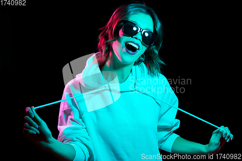Image of woman wearing hoodie in neon lights over black