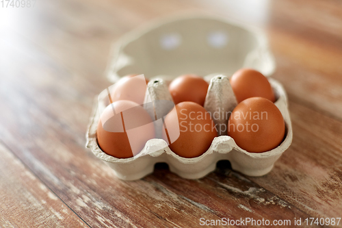 Image of close up of eggs in cardboard box on wooden table