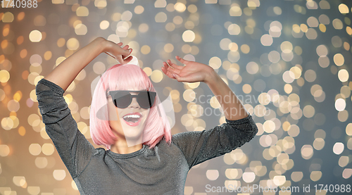 Image of happy woman in pink wig and sunglasses dancing