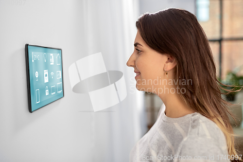 Image of woman looking at tablet computer at smart home