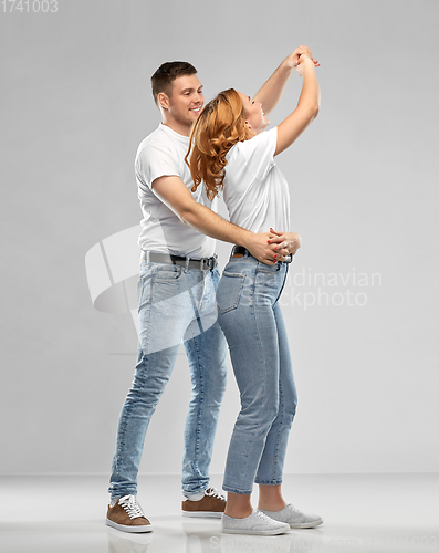 Image of portrait of happy couple in white t-shirts dancing