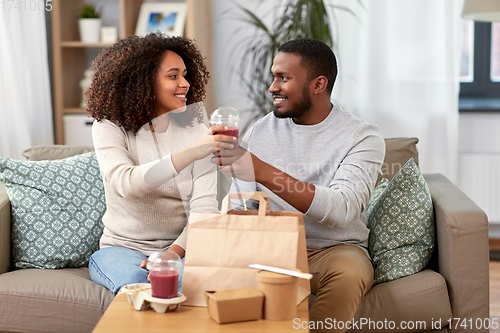 Image of happy couple with takeaway food and drinks at home