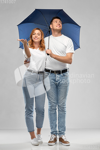 Image of happy couple in white t-shirts with umbrella