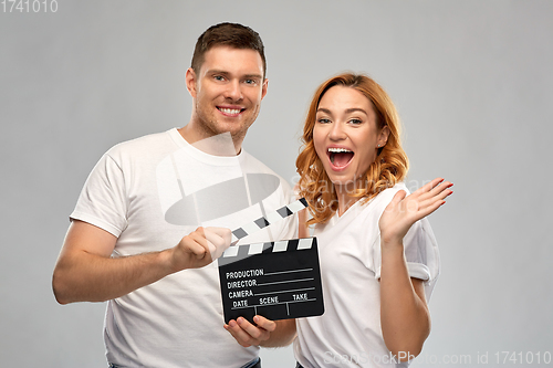 Image of happy couple in white t-shirts with clapperboard