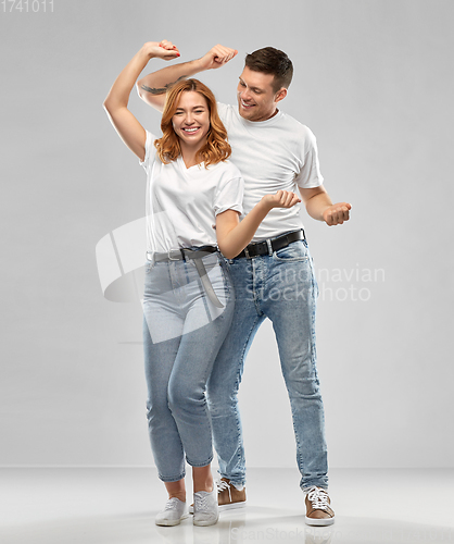 Image of portrait of happy couple in white t-shirts dancing