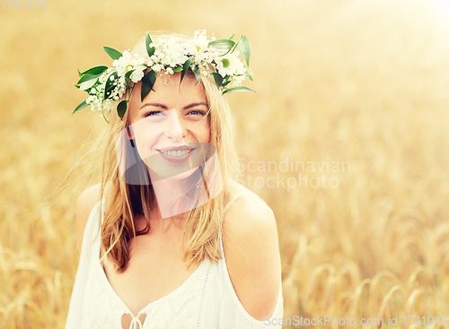 Image of happy young woman in flower wreath on cereal field