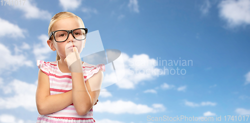 Image of girl in glasses thinking over sky background