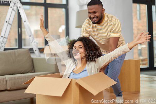 Image of happy couple moving to new home and having fun