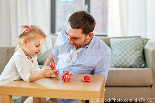Image of father and daughter playing tea party at home