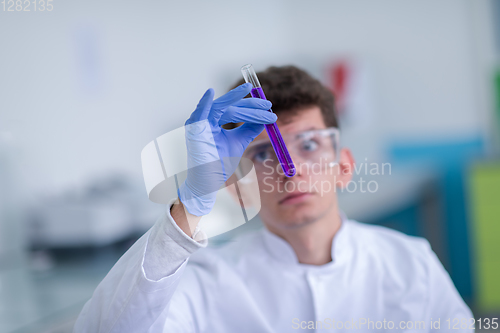 Image of student with protective glasses making chemistry experiment