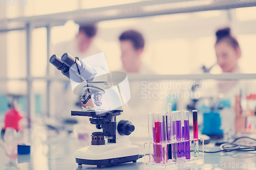 Image of Microscope on the workplace near test tubes