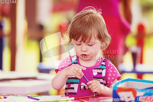 Image of little girl drawing a colorful pictures