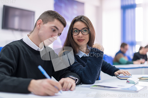 Image of young students writing notes