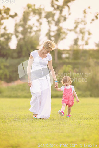 Image of mother and little daughter playing at backyard