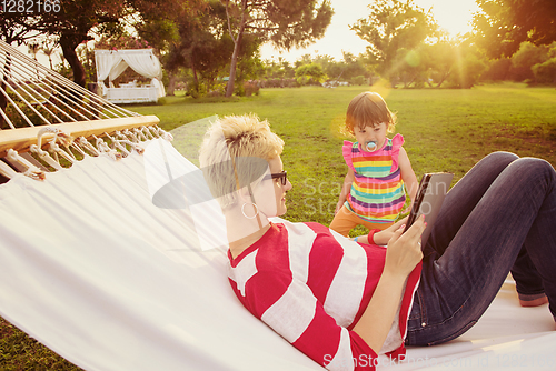 Image of mom and a little daughter relaxing in a hammock