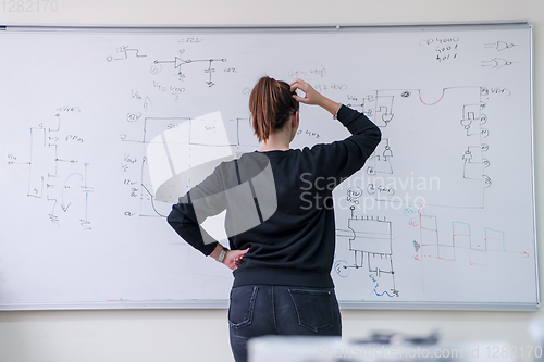 Image of female student writing on board in classroom