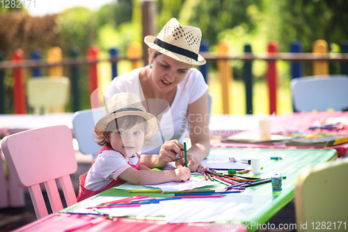 Image of mom and little daughter drawing a colorful pictures