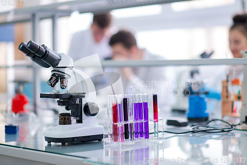 Image of Microscope on the workplace near test tubes