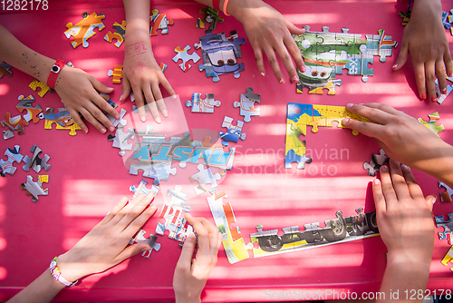 Image of top view of kids hands playing with puzzles