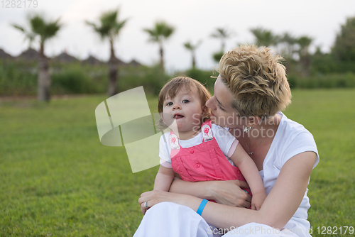 Image of mother and little daughter playing at backyard