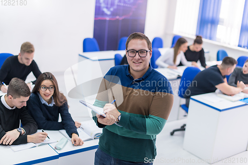 Image of male student with others writing notes