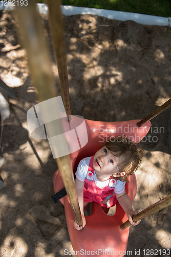 Image of little girl swinging  on a playground