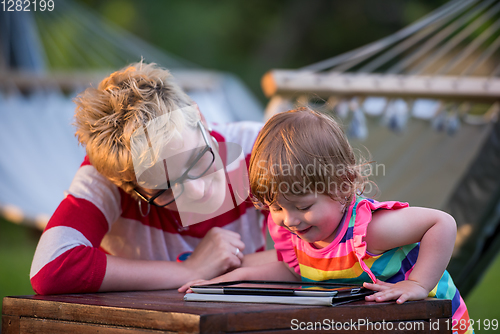 Image of mom and her little daughter using tablet computer