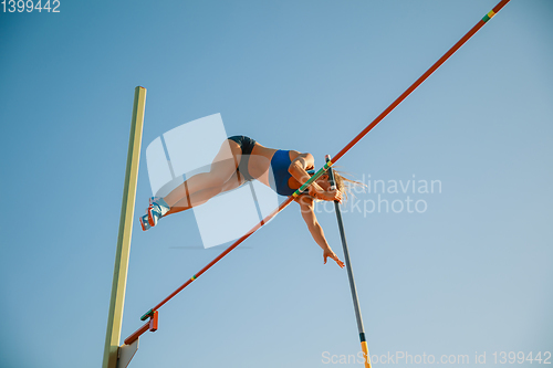 Image of Female high jumper training at the stadium in sunny day