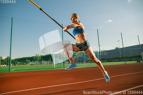 Image of Female high jumper training at the stadium in sunny day