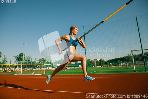 Image of Female high jumper training at the stadium in sunny day