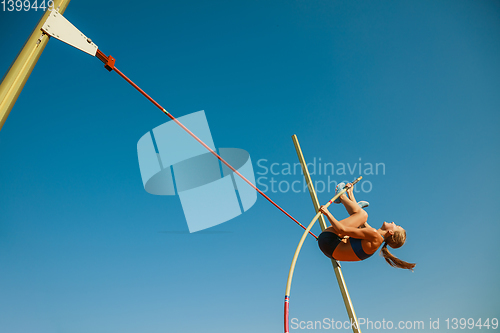 Image of Female high jumper training at the stadium in sunny day