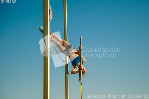 Image of Female high jumper training at the stadium in sunny day