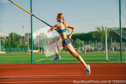 Image of Female high jumper training at the stadium in sunny day