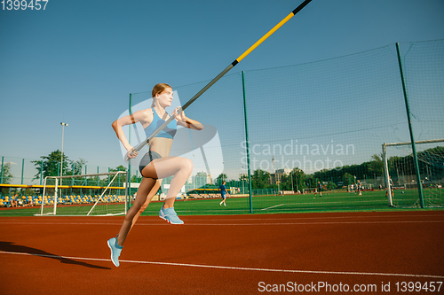 Image of Female high jumper training at the stadium in sunny day