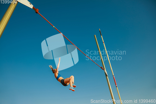 Image of Female high jumper training at the stadium in sunny day