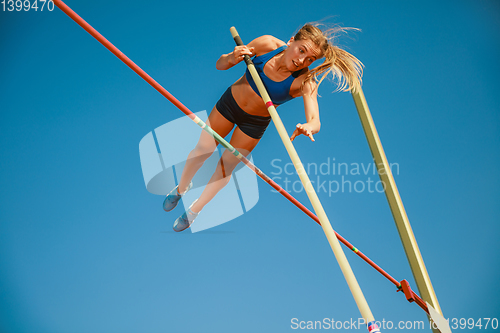 Image of Female high jumper training at the stadium in sunny day