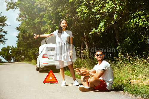 Image of Young couple traveling on the car in sunny day