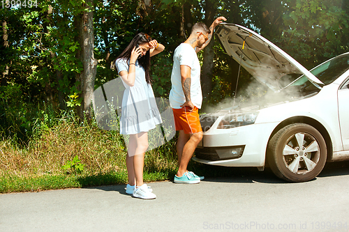 Image of Young couple traveling on the car in sunny day