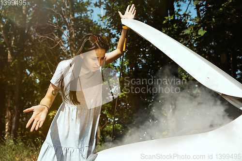 Image of Young woman traveling on the car in sunny day