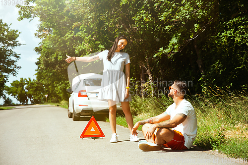 Image of Young couple traveling on the car in sunny day