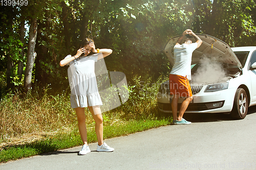 Image of Young couple traveling on the car in sunny day