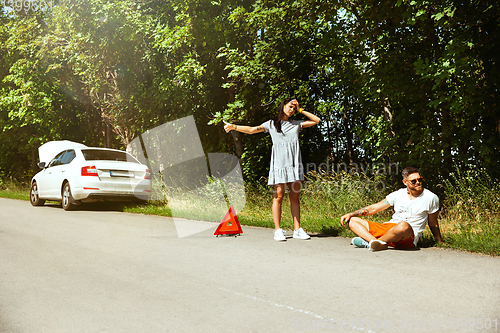 Image of Young couple traveling on the car in sunny day