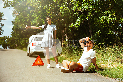 Image of Young couple traveling on the car in sunny day