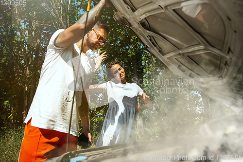 Image of Young couple traveling on the car in sunny day