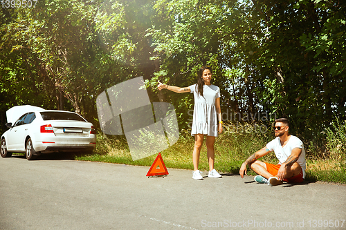 Image of Young couple traveling on the car in sunny day