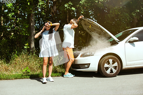 Image of Young couple traveling on the car in sunny day