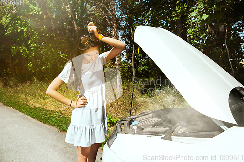 Image of Young woman traveling on the car in sunny day